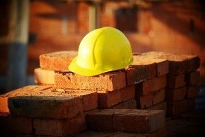 Under construction, helmet and bricks for building site