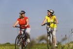 Pareja de mujeres paseando en bici por el campo.